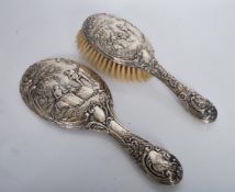 A silver hallmarked dressing table hair brush and matching hand mirror, the pair in relief depicting