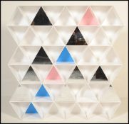 An unusual 20th Century wall shelving unit constructed from white plastic triangular shelves some