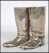 A pair of 20th Century silver plated drinks measures in the form of riding boots having raised