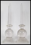 A pair of 20th Century glass obelisk centrepiece ornaments raised on square stepped bases with