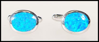 A pair of silver stamped 925 gentleman's cufflinks of oval form set with blue opals panels. Gross