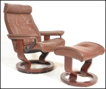 A retro 20th Century style tan / brown leather reclining swivel easy chair in the manner of Ekornes,