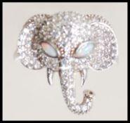 A stamped 925 silver ring in the form of an elephants head set with Cz's and opal eyes. Ring size P.