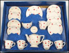 A mid 20th Century child's decorated pottery tea service by Ellar, four cups with saucers, side