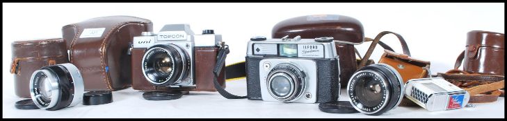 A vintage Topcon Uni film camera having a UV Topcor 53mm lens along with a 35mm and a 100mm lens