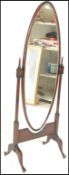 A 20th Century mahogany framed Cheval dressing bedroom mirror, the oval framed bevelled mirror