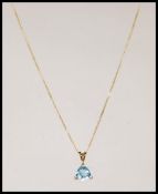 A 9ct gold fine lined ladies necklace chain set with a 9ct gold blue quartz pendant drop. Measures