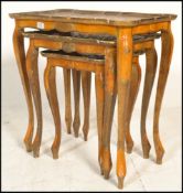 An Italian Florentine giltwood nest of three graduating tables on  decorated floral tops within