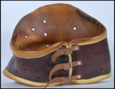 A 20th Century two tone leather medical back brace support / corset having three leather straps to