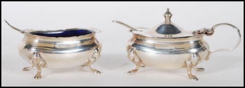 A pair of silver hallmarked table condiments complete with blue glass liners and condiment spoons.