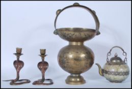 An early 20th Century Indian brass spittoon having a bulbous body engraved with foliate decoration