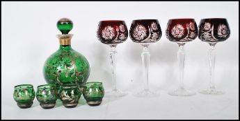 A believed 19th century Loetz manner silver overlay green glass Bohemian decanter and shot glass set