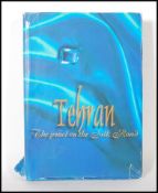 A large book entitled Tehran The Jewel on The silk Road published by Taher Inc. Art in