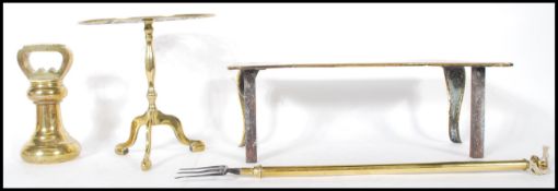 A collection of brass wares to include a 19th Century trivet raised on scroll supports, a 19th