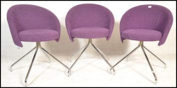 A set of three contemporary office chairs by Lyreco, the tub style seat pads covered in purple