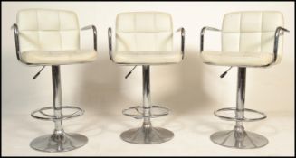 A set of three vintage 20th century adjustable bar stools raised on central chromed columns