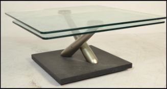 A contemporary  Naos coffee break glass swivel topped designer low table, stainless steel supports
