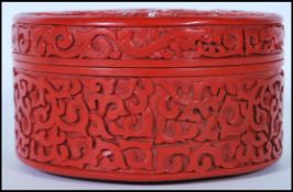 A 20th Century Chinese Cinnabar round desk top box of round form having carved relief of a Chinese