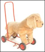 A vintage 1950's push / ride along upholstered Airedale terrier dog fixed to a tubular red painted