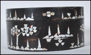 A late 19th / early 20th Century Chinese lacquered box of round form having mother of pearl inlay