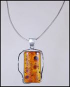 A silver stamped 925 necklace and pendant, the pendent having a Baltic Amber lozenge central panel