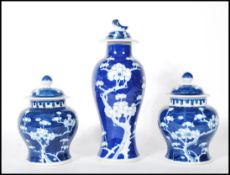A harlequin garniture of three Chinese blue and white lidded jars to include a pair of ginger jars