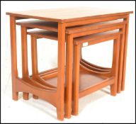 A 1960's vintage retro teak wood nest of three tables raised on rounded supports with stretchers,