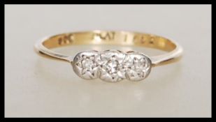 A stamped 9ct gold and platinum Art Deco ring having a platinum head set with three white stones.