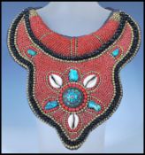 A 20th Century Tibetan tribal collar necklace constructed from a fabric panel stitched with red