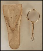 A pair of early 20th Century 1930's folding opera glasses with round lenses, having a yellow metal