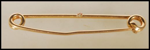 A 20th Century stamped 18ct gold safety pin brooch. Weight 7.5g. Measures approx 5cm wide.