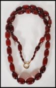 An early 20th Century circa 1930s simulated cherry amber graduating beaded necklace with gilt