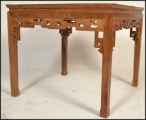 A 20th Century Chinese hardwood dining table of square form, with a foliate carved frieze, on square