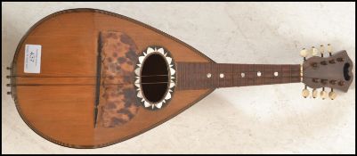 An early 20th Century antique eight string mandolin having a tear drop shaped body with mother of
