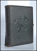 A 19th Century Victorian leather bound embossed photograph album with brass clasp containing several