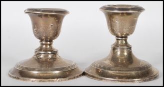 A near pair of silver hallmarked stub filled candlesticks, raised on circular bases, assay marks for