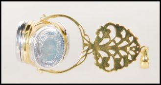 A silver gilt revolving three section picture locket pendant on a tree mount with pendant hook atop.