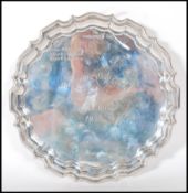 A solid silver hallmarked card tray / salver, scalloped edge raised on tripod feet, Sheffield