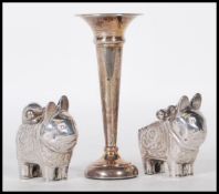 A pair of 20th Century Chinese cruets in the form of stylised cats having repousse floral sprays