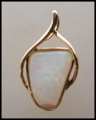 A stamped 14ct gold pendant having a crossover design set with an opal panel. Weight 1.5g.