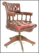 A 20th century oxblood red Leather Chesterfield Captains deep button back mahogany framed swivel