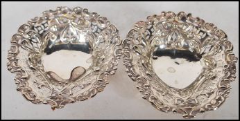 A pair of early 20th century silver pin dishes of rococo form with pierced basked design.