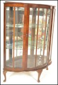 An early 20th Century walnut demi-lune china display cabinet with glazed panels, single door with