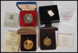A small group of coin pendant necklaces to include a sterling silver Valentine The Poetry of Love