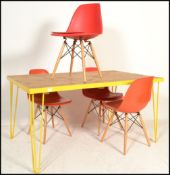 A retro style metal framed plank top dining table raised on hairpin upright supports in a yellow