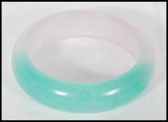 A vintage Chinese jade bracelet bangle, the two tone bangle of circular form. Measuring 6cm diameter