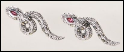 A pair of silver and marcasite set earrings in the form of snakes. Each one set with a single