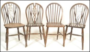 A set of four harlequin 20th Century beech and elm farmhouse dining chairs, the hoop back chairs
