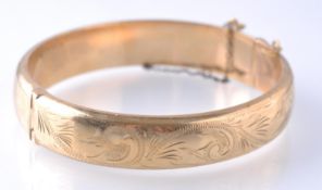 A HALLMARKED 9CT GOLD HINGED BANGLE