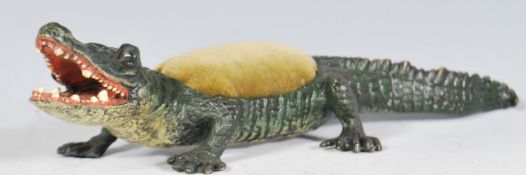 A cold painted bronze pincushion modelled as an al